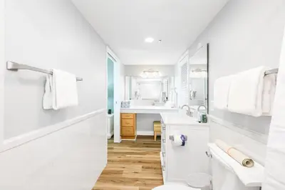 a white bathroom with a sink and a toilet at Landmark Holiday Beach in Panama City Beach