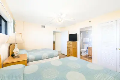 a hotel room with two beds and a television at Landmark Holiday Beach in Panama City Beach
