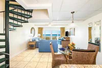 a living room with a blue couch and a table at Landmark Holiday Beach in Panama City Beach