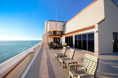 a balcony of a building with chairs and the ocean at Landmark Holiday Beach in Panama City Beach