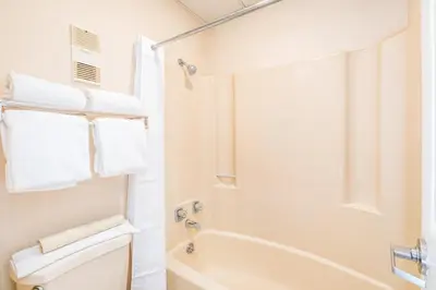 a bathroom with a tub and a toilet and towels at Landmark Holiday Beach in Panama City Beach