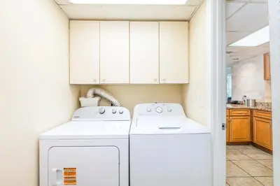 a kitchen with white cabinets and a washer and dryer at Landmark Holiday Beach in Panama City Beach