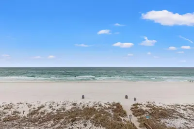 an empty beach with the ocean in the background at The Reef At Seahaven Beach Resorts in Panama City Beach