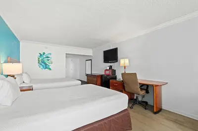 a hotel room with a bed and a desk with a computer at The Reef At Seahaven Beach Resorts in Panama City Beach