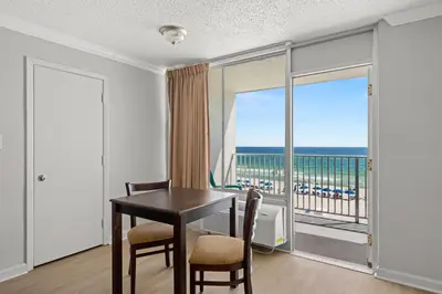 a dining room with a table and a view of the ocean at The Reef At Seahaven Beach Resorts in Panama City Beach