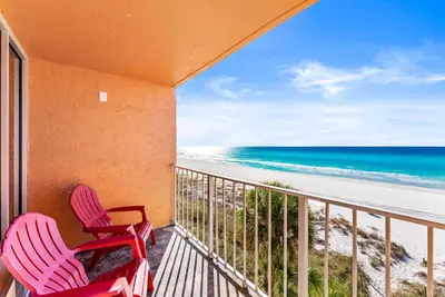 a balcony with two chairs and the beach at Seahaven Beach Hotel Panama City Beach in Panama City Beach
