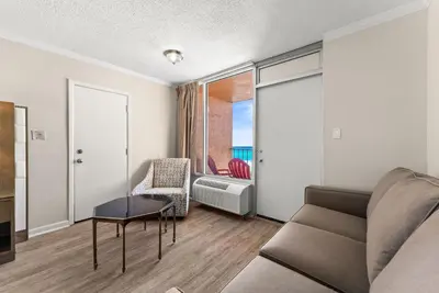 a living room with a couch and a table at Seahaven Beach Hotel Panama City Beach in Panama City Beach