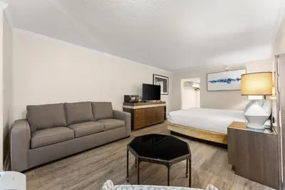 a hotel room with a bed and a couch at Seahaven Beach Hotel Panama City Beach in Panama City Beach