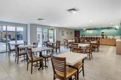 a restaurant with tables and chairs and a bar at Garner Hotel Panama City Beach Northeast by IHG in Panama City Beach