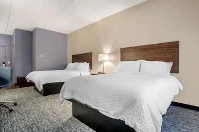 a hotel room with two beds and a chair at Garner Hotel Panama City Beach Northeast by IHG in Panama City Beach