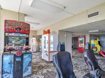 a gaming room with two arcade machines and a video game at Windward 604 at Edgewater in Panama City Beach