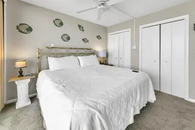 a bedroom with a large white bed and two lamps at Windward 604 at Edgewater in Panama City Beach
