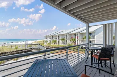 a balcony with a table and chairs and the beach at Walton Dunes 2 in Santa Rosa Beach