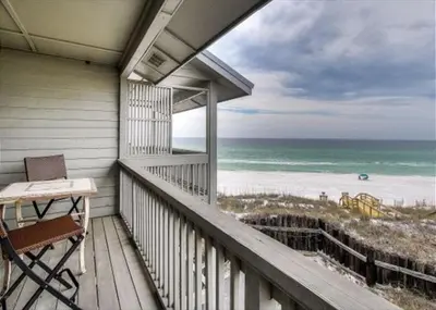 a balcony with a table and a chair and the ocean at Walton Dunes 2 in Santa Rosa Beach