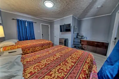 a hotel room with two beds and a television at Aqua View Motel in Panama City Beach