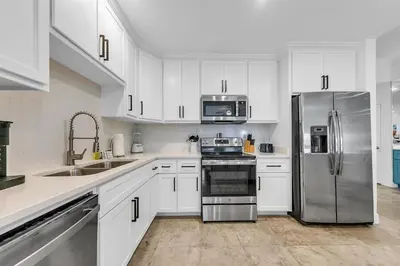 a kitchen with white cabinets and a stainless steel refrigerator at Legacy 104 in Santa Rosa Beach