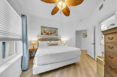 a white bedroom with a large bed and a chandelier at Legacy 104 in Santa Rosa Beach