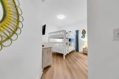 a white room with a crib and a baby crib at Legacy 104 in Santa Rosa Beach
