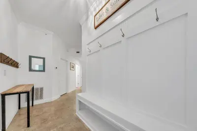 a hallway with white walls and a wooden table at Legacy 104 in Santa Rosa Beach