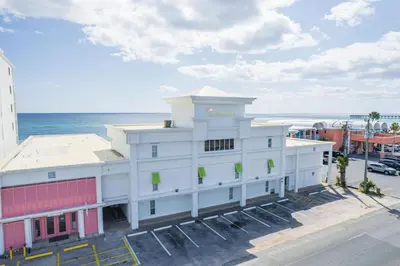 a white building with the ocean in the background at Flamingo Hotel & Tower in Panama City Beach
