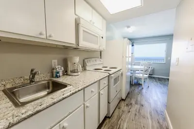 a kitchen with a sink and a stove top oven at Flamingo Hotel & Tower in Panama City Beach