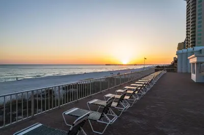 a row of chairs on the beach at sunset at Flamingo Hotel & Tower in Panama City Beach