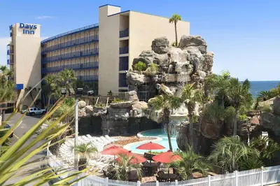 a hotel with a swimming pool and a resort at Days Inn by Wyndham Panama City Beach Beachfront Resort in Panama City Beach