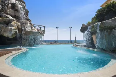 a large swimming pool with a water slide at Days Inn by Wyndham Panama City Beach Beachfront Resort in Panama City Beach