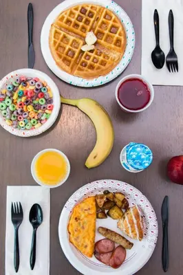a table with plates of breakfast food and a banana at Hampton Inn & Suites Panama City Beach-Beachfront in Panama City Beach