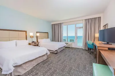 a hotel room with two beds and a flat screen tv at Hampton Inn & Suites Panama City Beach-Beachfront in Panama City Beach