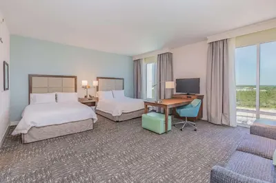 a hotel room with two beds and a desk with a computer at Hampton Inn & Suites Panama City Beach-Beachfront in Panama City Beach