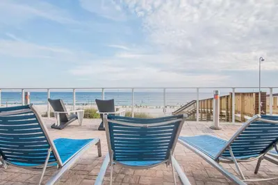 three chairs and a table on the beach at Hampton Inn & Suites Panama City Beach-Beachfront in Panama City Beach