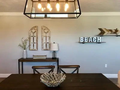 a dining room with a table and a chandelier at Regency Towers - beachfront condo in Panama City Beach