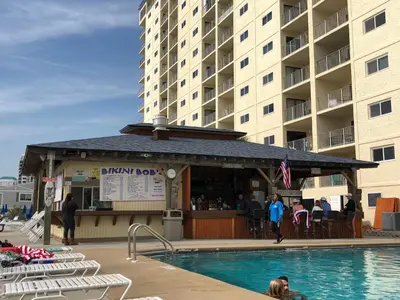 a swimming pool in front of a large building at Regency Towers - beachfront condo in Panama City Beach