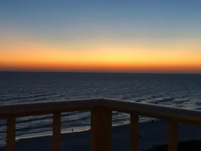 a view of the ocean at sunset from a balcony at Regency Towers - beachfront condo in Panama City Beach