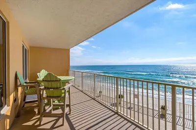 a balcony with a table and chairs and the ocean at Treasure Island 0202 in Panama City Beach