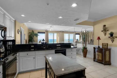a large kitchen with black counter tops and windows at Treasure Island 0202 in Panama City Beach