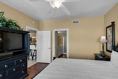 a bedroom with a bed and a flat screen tv at Treasure Island 0202 in Panama City Beach