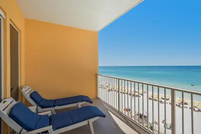 a balcony with chairs and a view of the beach at Treasure Island 0510 in Panama City Beach