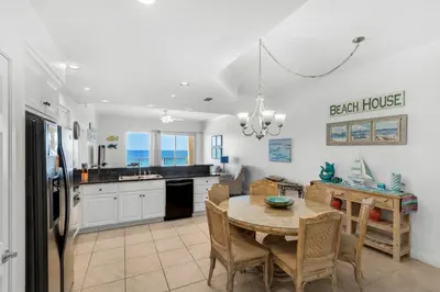 a kitchen and dining room with a table and chairs at Treasure Island 0510 in Panama City Beach