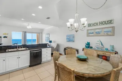 a kitchen with a dining table and a beach house at Treasure Island 0510 in Panama City Beach