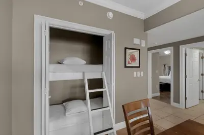 a bunk bed in a room with a chair at Treasure Island 0602 in Panama City Beach