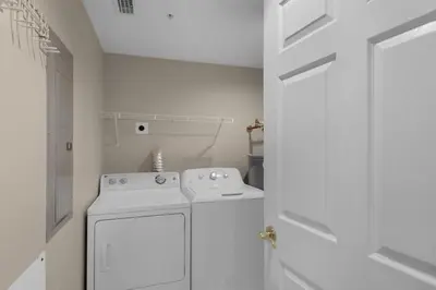 a white laundry room with a washer and dryer at Treasure Island 0602 in Panama City Beach