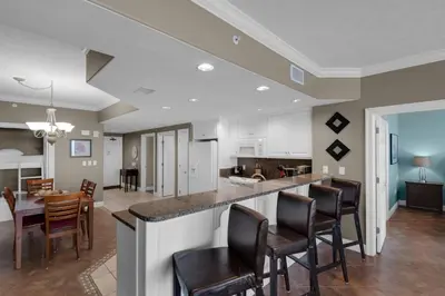 a kitchen and dining room with a table and chairs at Treasure Island 0602 in Panama City Beach