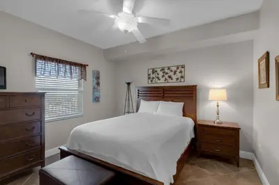 a bedroom with a bed and a ceiling fan at Treasure Island 0602 in Panama City Beach