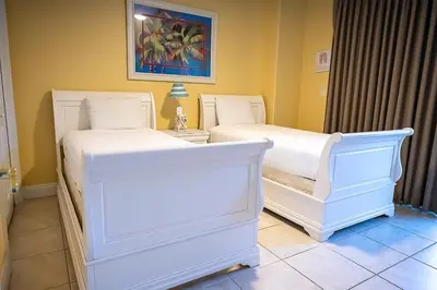two beds in a room with white beds at Treasure Island 0212 in Panama City Beach