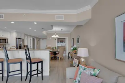 a living room and kitchen with a couch and a table at Treasure Island 0211 in Panama City Beach