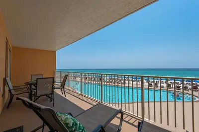 a balcony with a view of a pool and the ocean at Treasure Island 0211 in Panama City Beach