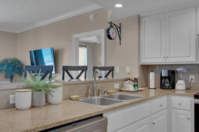 a kitchen with white cabinets and a sink at Treasure Island 0211 in Panama City Beach