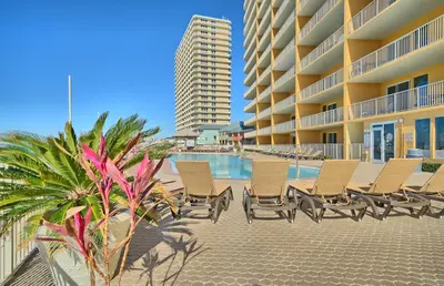 a row of chairs next to a swimming pool at a resort at Treasure Island 0211 in Panama City Beach